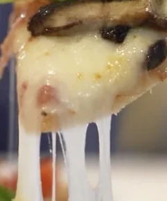 Pizza con mozzarella que se estira y champiñones